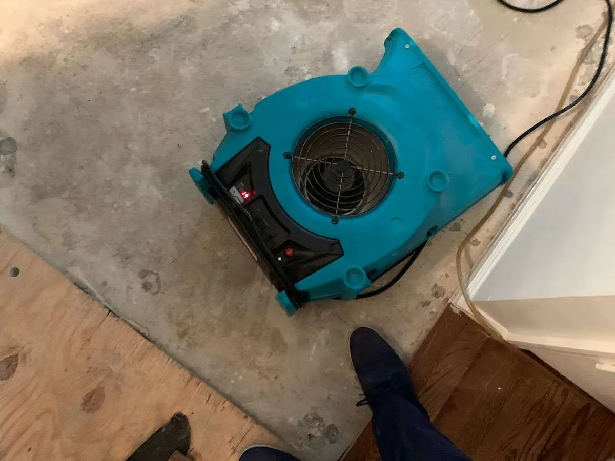 Air mover drying subfloor during Leak Detection & Repair in Poland